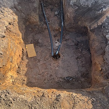 2 pipes running into a hole in the ground